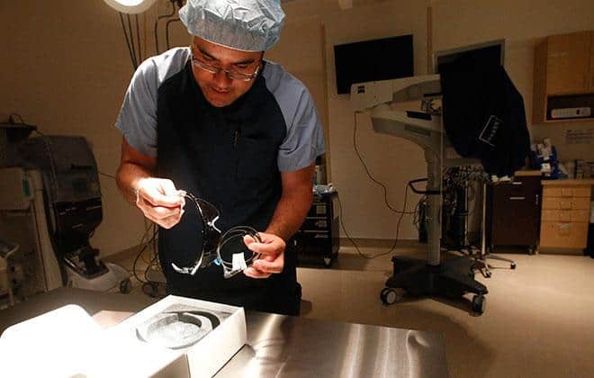 Ronald M. Walker, clinical director of the Eye Surgery Center of Hawaii, unwraps the Argus II artificial retina inside one of the center’s operating rooms.  Photo by Jamm Aquino.